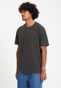 Donkergrijze katoenen T-shirt met ronde hals en korte mouwen, voorzien van een klein merklogo op de borst en een losse pasvorm.