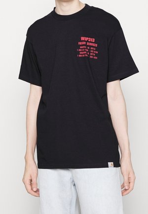 Sort kortærmet t-shirt med rød tekst "WIP313 Freight Services" og kontaktoplysninger på brystet, båret med lyseblå jeans.