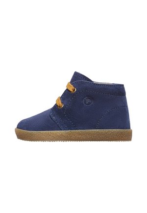 Stivali alla caviglia in suede blu navy con lacci marroni, Suola marrone testurizzata e logo circolare sul lato esterno, con accenti di cuciture diagonali.