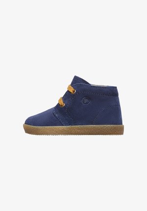 Stivali alla caviglia in suede blu navy con lacci marroni, Suola marrone testurizzata e logo circolare sul lato esterno, con accenti di cuciture diagonali.
