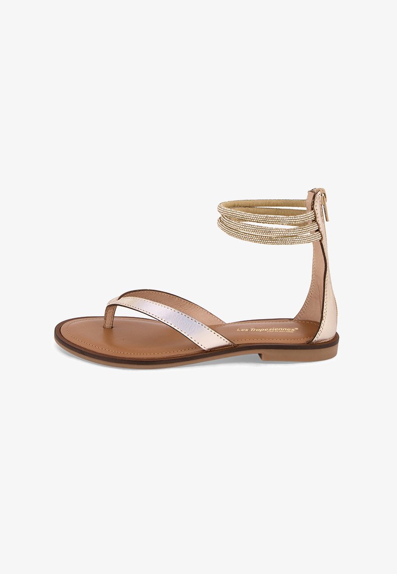 Sandali bassi con suola in pelle marrone, cinturini metallici e un dettaglio decorativo alla caviglia con più bande dorate.