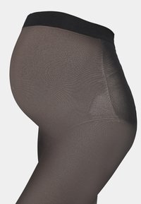 Collants noirs transparents avec une large taille noire, présentant une texture lisse et une coupe ajustée, adaptés à divers vêtements.