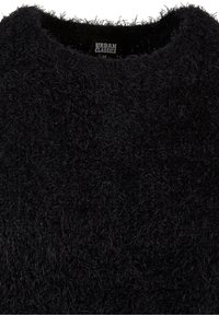 Pull noir en tissu pelucheux avec un col rond, montrant une étiquette de marque "Urban Classics" cousue à l'intérieur du col.