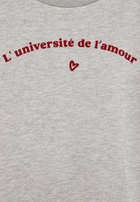 Siva majica s sivo-burgundnim napisom "L'université de l'amour" in majhnim srcem pod napisom.