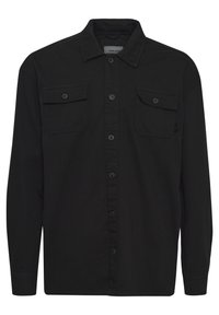Zwart overhemd met lange mouwen van zacht stof, met een puntkraag, twee voorzakken en knoopsluitingen over de voorkant.