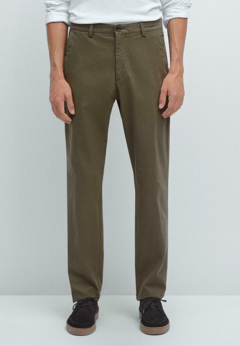 Khaki chinos med en slät textur, raka bendesign och två sidofickor. I kombination med mörkbruna snörskor.