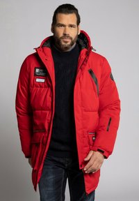 Rød isoleret parka med hætte, der har sort hardware og patches. Quiltet design, lynlåslommer og en afslappet pasform.