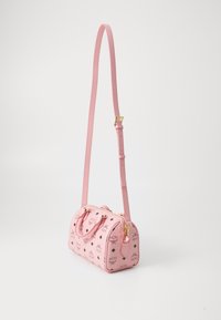 Bolso mini de piel rosa con herrajes dorados, cremallera superior y dos asas. Presenta un patrón de diamantes en negro y una correa de hombro ajustable.