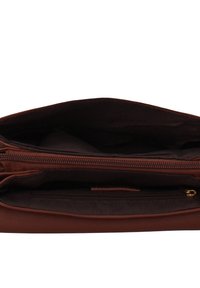 Bruine leren handtas met een ritssluiting, met een ruim interieur en een extra ritssluitingvak voor organisatie. Textuurstof voering zichtbaar.