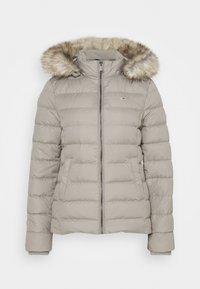 Beige péřová bunda se zipem vpředu, žebrovanými manžetami a kapucí lemovanou umělou kožešinou. Má prošívaný design a boční kapsy.