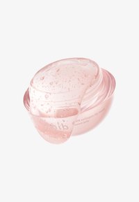Masque pour les lèvres au collagène dans un récipient rose semi-transparent avec un couvercle clair en forme de dôme, présentant une texture gélatineuse et des gouttelettes d'eau visibles.