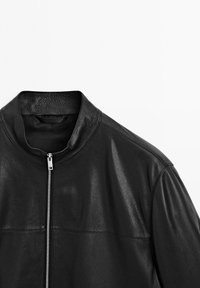 Black leather jacket with a silver front zipper and a short stand collar, displayed on a white background.