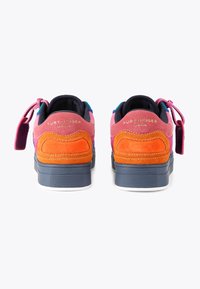 Sneaker in suede colorato con pannelli rosa, arancioni e viola, dotati di una suola blu navy e marchio sul tallone.