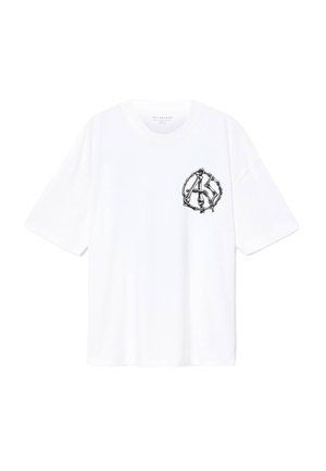 T-shirt blanc à manches courtes avec un col rond et un petit graphique noir d'un symbole de paix squelettique sur la poitrine gauche.