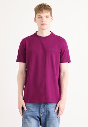 T-skjorte med kort erme og rund hals i solid mørk magenta bomull, med en subtil brodert logo på venstre bryst. Avslappet passform.
