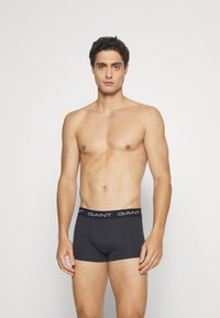 Herren schwarze Boxerbriefs aus Baumwolle, mit GANT-Logo auf dem elastischen Bund, enganliegendem Design und glatter Textur.