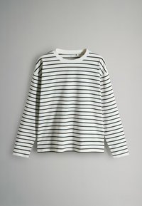 White long-sleeve shirt with black horizontal stripes, round neckline, and a relaxed fit, displayed against a plain light gray background.