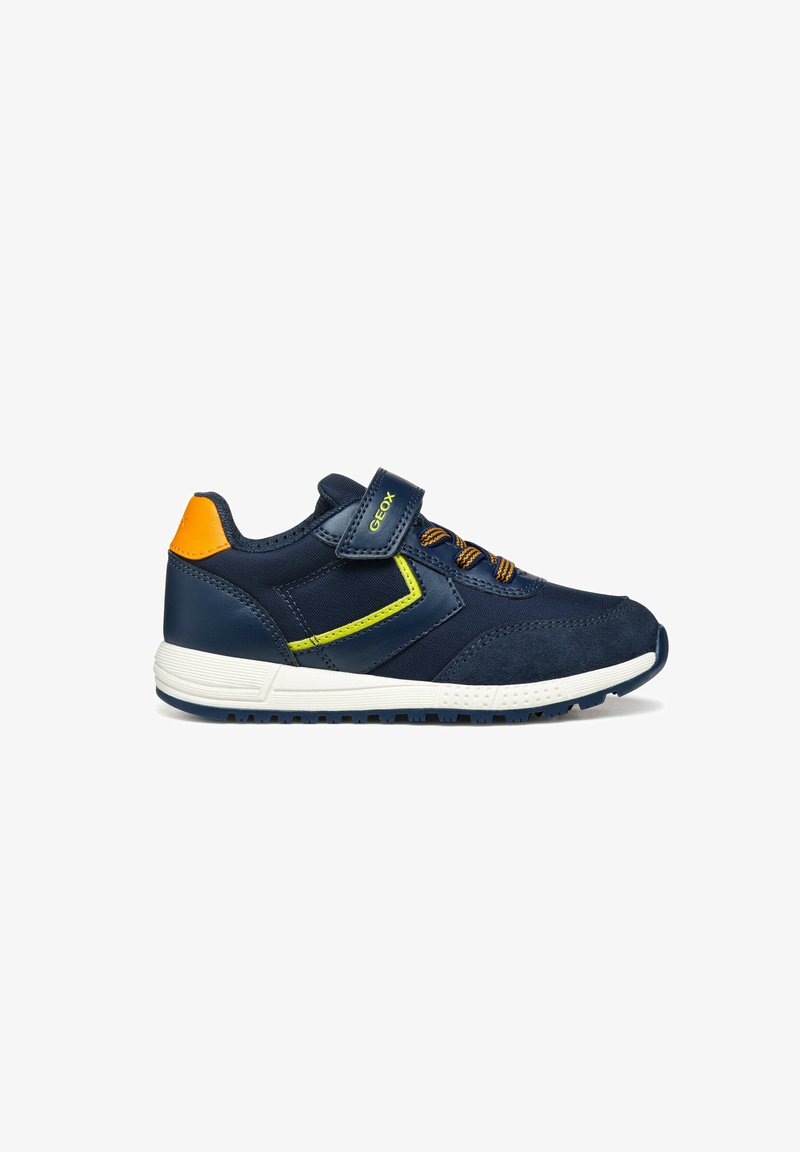 Sneakers blu navy con materiali in suede e mesh, suola bianca, accentuazione arancione sul tallone e dettagli in verde neon. Chiusura con una fascia in Velcro.