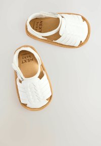 Vita baby sandaler som är gjorda av mjukt material, med en vävd design på överdelen, korkfotbädd och justerbar rem för en säker passform.