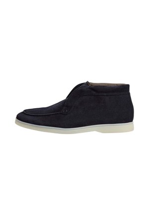Zwarte suède mid-top schoen met witte zool, moc toe ontwerp en slip-on stijl, zijaanzicht op witte achtergrond.