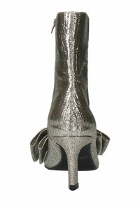 Glitterende zilveren enkellaars met een strakke pasvorm, hoge hak en rimpelaccent bij de enkel. Gladde textuur met een glanzende afwerking.
