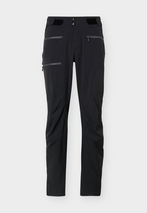 Pantaloni negri de exterior cu mai multe buzunare cu fermoar și clapete reglabile la talie, concepuți pentru drumeții sau activități sportive.