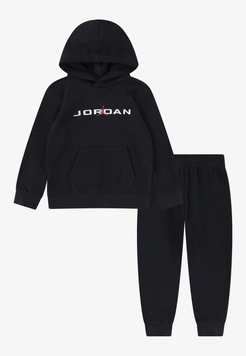 Fekete kapucnis pulóver és az ahhoz illő melegítőnadrág szett, puha anyagból. Elől zseb található, a "JORDAN" logó fehér színben, piros részletekkel.