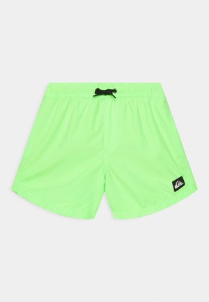 Bañador corto de color verde neón hecho de una tela ligera y de secado rápido. Presenta una cintura elástica con cordón negro y un parche con logo.