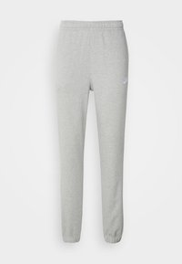 Svetle šedé Nike tepláky s elastickým pasem a manžetami, malým bílým logem Nike na levém stehně, vystavené na bílém pozadí.