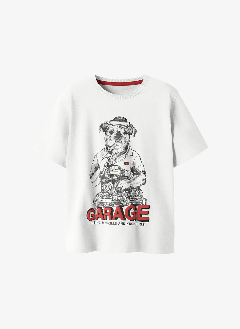 T-shirt blanc avec illustration d'un chien portant un chapeau et une chemise, tenant un moteur mécanique, avec le texte "GARAGE" en dessous.