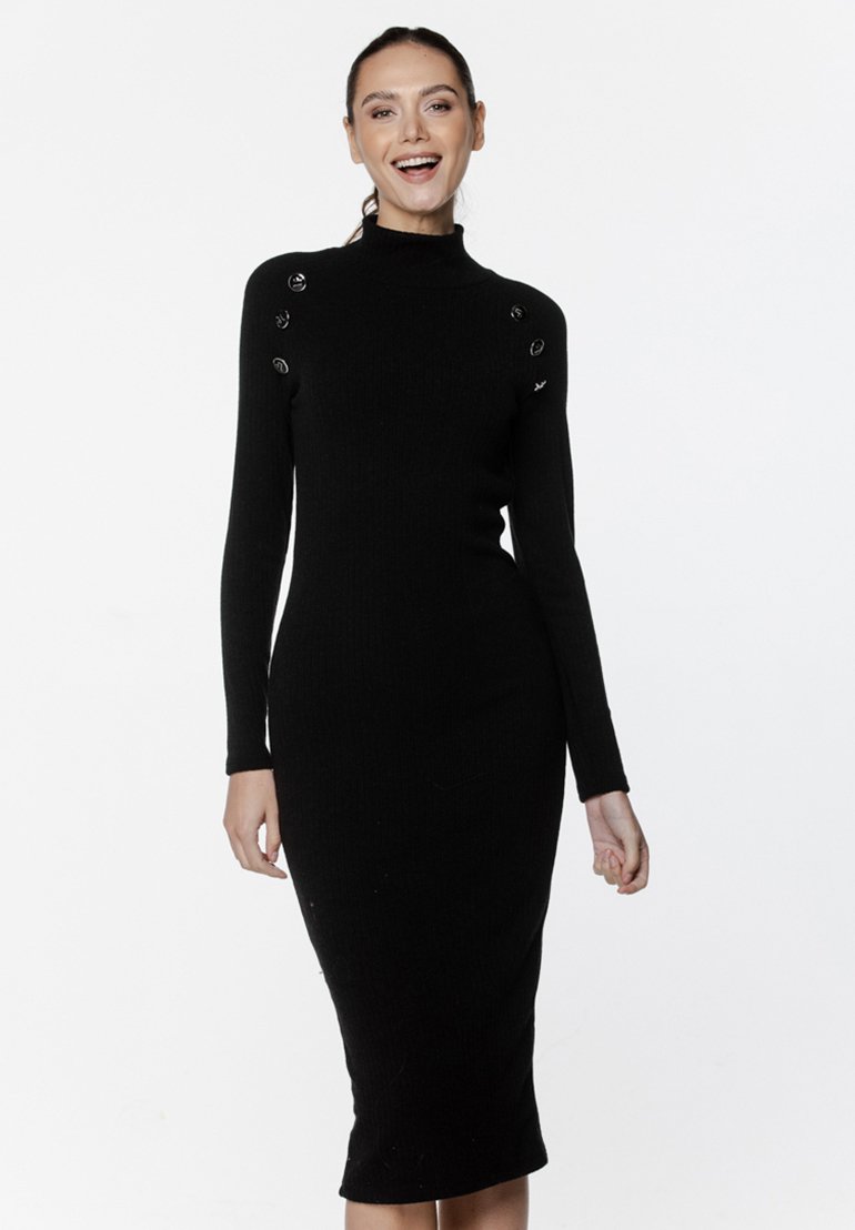 Czarna dzianinowa sukienka z prążkowanej tkaniny, z długimi rękawami, wysokim kołnierzem i srebrnymi guzikami na ramionach. Dopasowany krój do długości w połowie łydki.