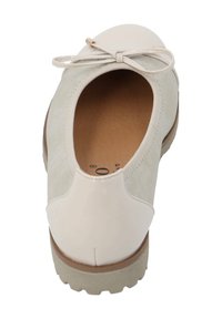 Zapato de color beige claro con punta de charol suave y cuerpo de ante texturizado. Presenta un lazo como detalle y una suela de goma resistente para mayor agarre.