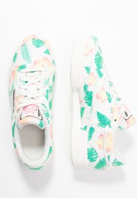 Sneaker bianchi decorati con un motivo floreale e fogliare tropicale nei toni del verde, rosa e giallo; presentano una tomaia testurizzata e un laccio frontale.