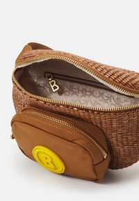 Borsa intrecciata marrone con un compartimento principale con zip e una tasca marrone più piccola attaccata, caratterizzata da un accento circolare giallo con la lettera "B".