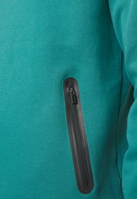 Felpa color teal con una texture liscia e tasca laterale con zip nera, caratterizzata da un design elegante e una forma aderente.