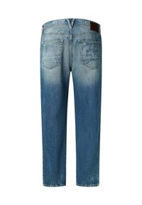 Jeans de mezclilla azul claro con un acabado desgastado, que cuentan con cinco bolsillos y una etiqueta de cuero marrón en la cintura, mostrando un sutil detalle del logo.