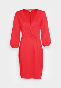 Robe portefeuille rouge avec un col en V, des manches longues bouffantes, une taille élastique et des poches latérales, fabriquée dans un tissu lisse et extensible.