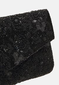 Zwarte parel clutch met bloemmotieven, gestructureerd oppervlak met verschillende maatjes van parels en een omvouwsluiting.