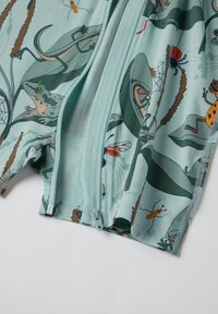 Vandtematiske shorts i lys teal med lynlås, prydet med farverige illustrationer af frøer, insekter og planter på et glat stof.