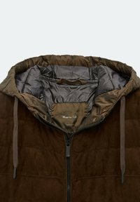 Veste matelassée marron avec capuche, fermeture éclair à l'avant et cordons de serrage, vue de la poitrine supérieure jusqu'à la doublure de la capuche.