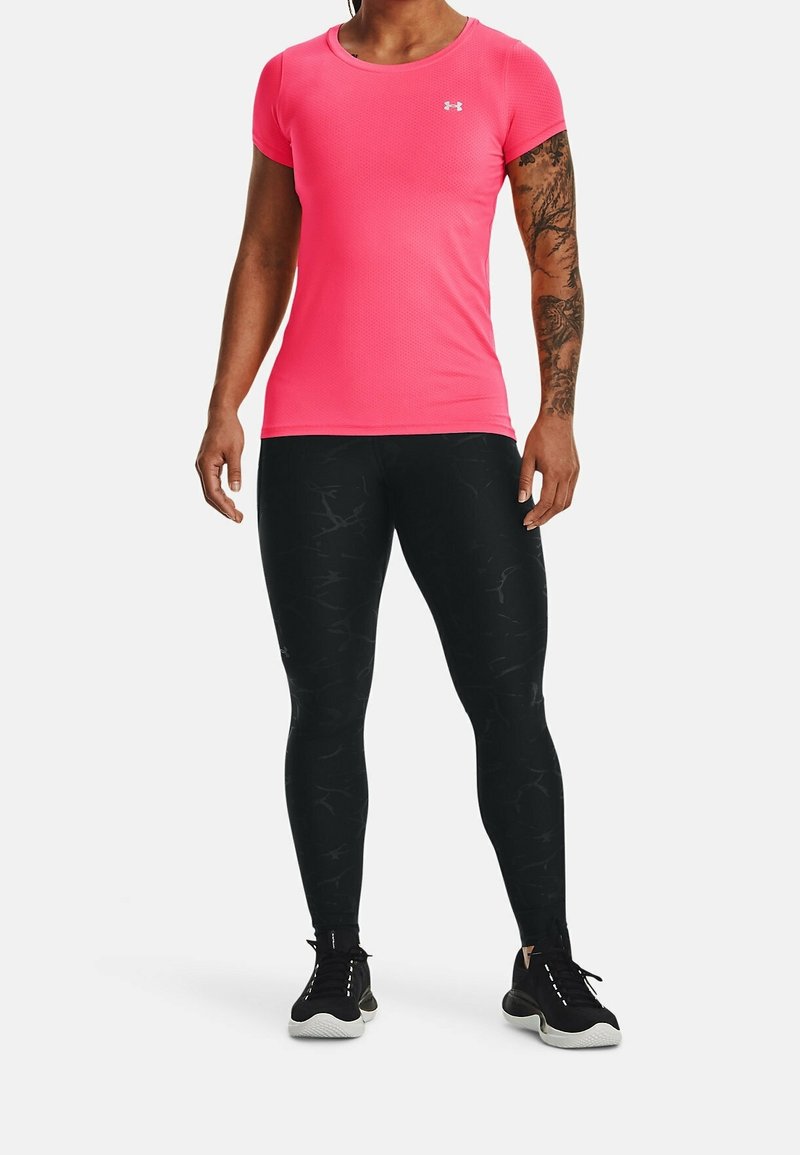 Ljusrosa figursydd kortärmad skjorta i texturerat tyg, kombinerad med svarta mönstrade leggings och svarta träningsskor med vita sulor.