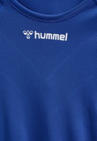 Blaues Sportshirt mit strukturierter Oberfläche. Mit einem runden Halsausschnitt und einem weißen "hummel"-Logo auf der Brust.