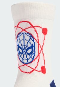 Biała skarpetka z niebieskim logo twarzy Spider-Mana, otoczona czerwonym wzorem atomu. Posiada miękką teksturę i żebrowany mankiet na górze.