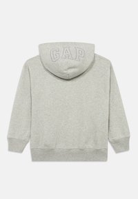 Sudadera con capucha de algodón gris con cordón, presenta una textura suave y el logo "GAP" bordado en gris claro en la parte trasera.