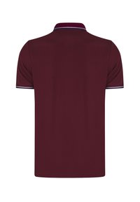 Camisa polo burdeos con un tejido texturizado. Presenta un cuello y un borde de manga en contraste. Dobladillo recto y mangas cortas.
