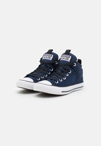 Mörkblå hög-top sneakers med ovandel i canvas, vit gummitå, svarta snören och logotypapplikation på tungan. Texturerad sula.