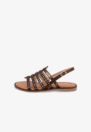 Sandale en cuir marron avec plusieurs larges brides présentant des perforations blanches et un petit talon. Bride de cheville ajustable avec boucle dorée.