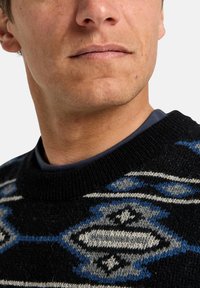 Suéter preto de malha com um design geométrico em tons de azul e cinza. Gola redonda com uma textura suave e detalhe de camada interna contrastante.