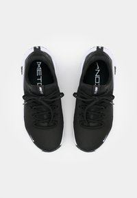 Zwarte sportschoenen met een gestructureerde bovenkant, voorzien van een witte zool, ronde neus en zwarte veters. Merkennaam zichtbaar op de tong.