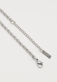 Silver metal chain, featuring interconnected links, a lobster clasp, and a rectangular tag with a simple design. Smooth texture throughout.